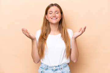 Young caucasian woman isolated on beige background smiling a lot