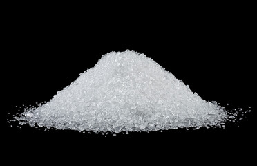 Pile of white salt on a black background. Crystals of sea salt.