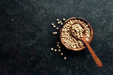 Chickpeas beans in a wooden spoon. on a stone background. Healthy food.