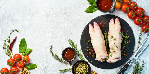 Raw pork legs are ready to cook with spices and herbs. Meat. On a black background.