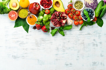 Healthy organic food: fresh vegetables and fruits on a white wooden background. Free space for your text.