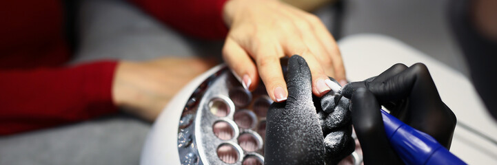 Nail master use special equipment for working with clients manicure - obrazy, fototapety, plakaty