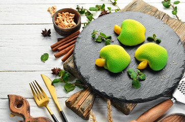 Dessert. Cream cakes in the shape of a green apple. Sweets. Top view. Rustic style.