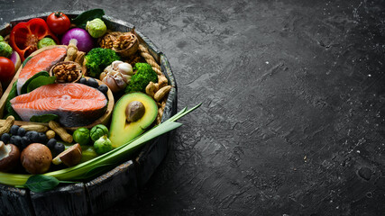 Set of healthy food in a box. On a black stone background. Side view. Copy space.