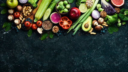 Organic food on a black stone background. Vegetables and fruits. Top view. Free copy space.