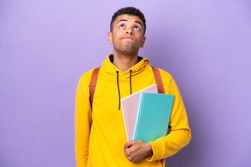 Young student Brazilian man isolated on purple background and looking up