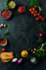 Fototapeta na wymiar Black stone cooking background. Spices and vegetables. Top view. Free space for your text.