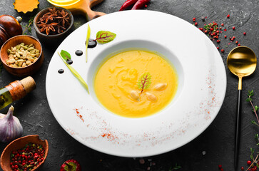Pumpkin soup with vegetables and spices. Autumn restaurant menu. top view. Free space for text.