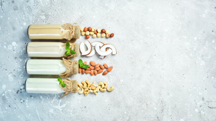 Set of vegan lactose-free nut milk in bottles on a stone background. healthy food. Free space for text.