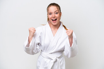 Young caucasian girl doing karate isolated on white background celebrating a victory in winner position © luismolinero