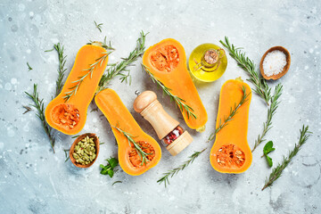 Preparation of pumpkin dishes. Fresh pumpkin with rosemary and spices. On a stone background. Top view.