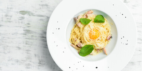 Pasta carbonara with egg yolk. Italian cuisine. Menu. Top view.