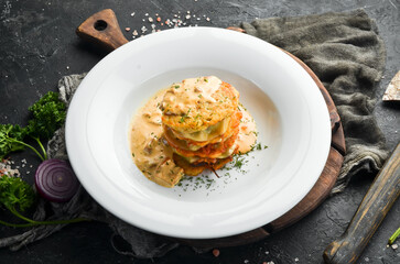 Potato pancakes with mushroom sauce. On a white plate. Restaurant menu. Top view.