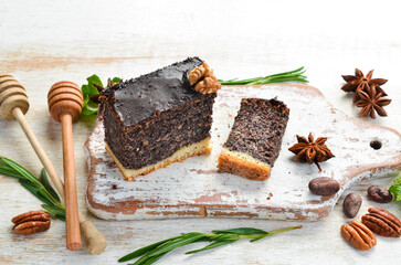 Poppy seed cake with chocolate and nuts. Dessert. On a black background. Top view.