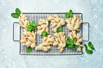 Fresh ginger and green mint. Free space for text, on stone background.