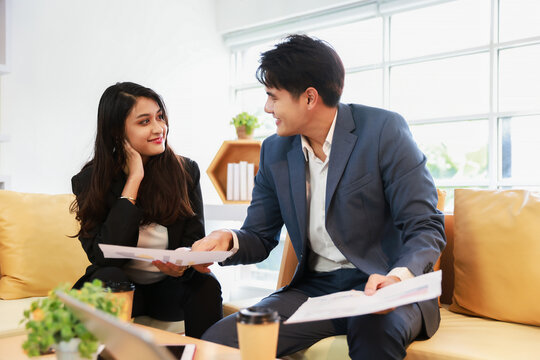 Businessman and businesswoman sit on couch working and having discussion meeting together, Business couple in modern office
