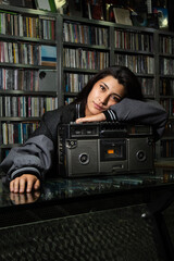 retrato de mujer joven en una tienda de discos sobre una grabadora clasica de los años 80´s