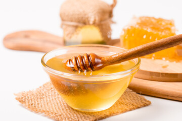 Honey dripping from a wooden honey dipper on white background. Healthy organic food concept. 