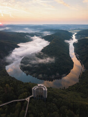 The Saar Loop at the viewpoint Cloef at Orscholz near Mettlach in Germany. Aerial view of curvy River at misty sunrise