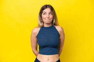 Obraz premium Young Rumanian woman isolated on yellow background having doubts while looking up