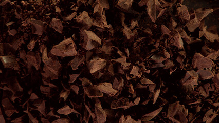 Freeze motion of flying group of raw chocolate pieces.