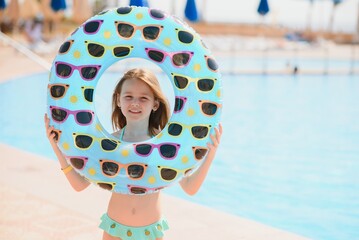 The concept of recreation at sea. The girl holds an inflatable circle for swimming by the pool