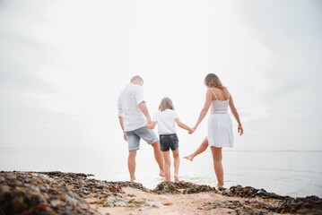 Happy family walking on the beach