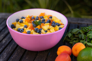 salade de fruits frais d'été posée sur une table en bois avec des fruits et de la menthe. Bon pour rester en bonne santé