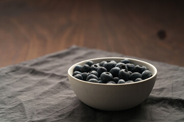 Fototapeta na wymiar Fresh organic blueberries in a white bowl closeup