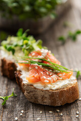 Sandwiches with salted salmon,  avocado and microgreens.