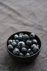 Freshly washed organic blueberries in a black bowl closeup