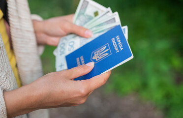 Fototapeta na wymiar a girl holds in her hands a Ukrainian biometric passport with Poland zloty banknotes