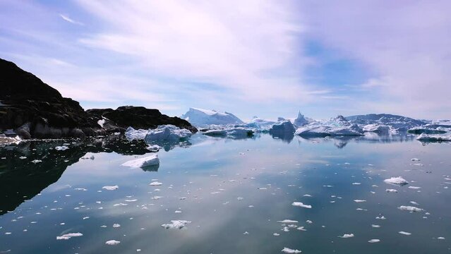 Greenland. Icebergs. Nature and landscapes of Greenland. Disko bay. West Greenland. Summer Midnight Sun and icebergs. Big blue ice in icefjord. Climate change and global warming.