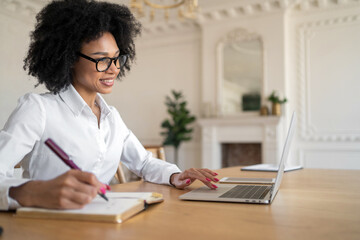 A woman works in an office coworking space, an online report in the company prints a message uses a laptop computer