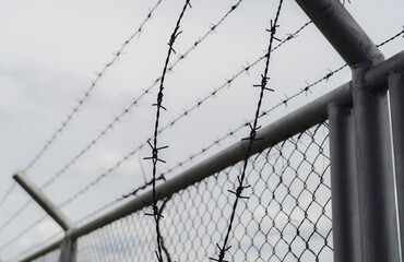Prison security fence. Border fence. Barbed wire security fence. Razor wire jail fence. Boundary security wall. Prison for arrest of criminals or terrorists. Private area. Military zone concept.