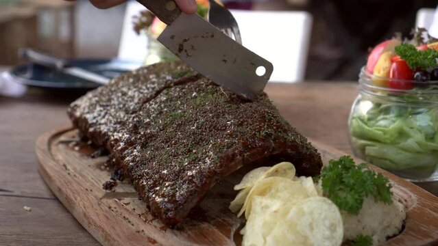 Hands Cutting Bbq Pork Ribs Cover In Sauce And Spices Rustic Yummy American Style Grill