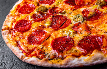 Pepperoni Pizza with Mozzarella cheese, salami, Tomato sauce, pepper, Spices. Italian pizza on Dark grey black slate background