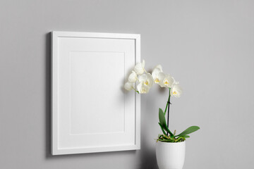 Blank vertical frame mockup with white orchid flower