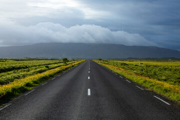 Very picturesque empty road in iceland in summer. Asphalt road as a symbol of freedom and travel.