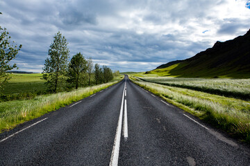 Very picturesque empty road in iceland in summer. Asphalt road as a symbol of freedom and travel.