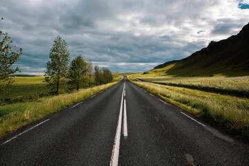 Very picturesque empty road in iceland in summer. Asphalt road as a symbol of freedom and travel.