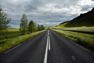 Very picturesque empty road in iceland in summer. Asphalt road as a symbol of freedom and travel.