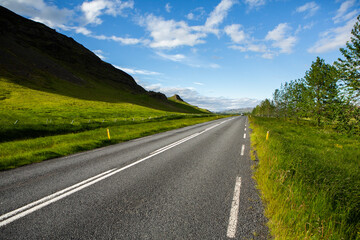 Very picturesque empty road in iceland in summer. Asphalt road as a symbol of freedom and travel.