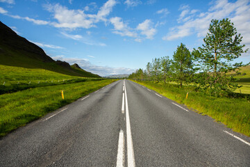 Very picturesque empty road in iceland in summer. Asphalt road as a symbol of freedom and travel.