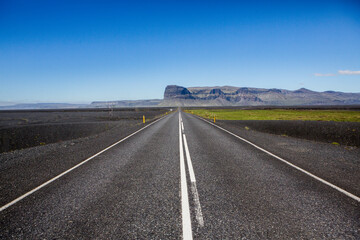 Very picturesque empty road in iceland in summer. Asphalt road as a symbol of freedom and travel.