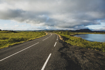 Very picturesque empty road in iceland in summer. Asphalt road as a symbol of freedom and travel.