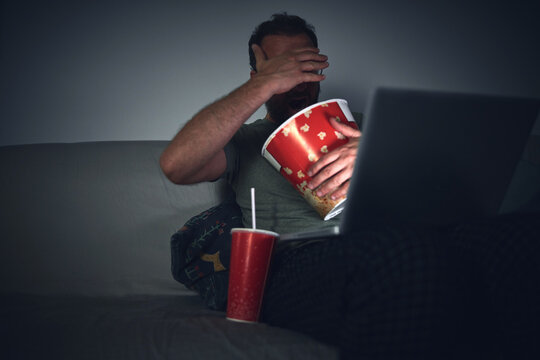 Adult Man Watching Movies At Home, Eating Popcorn And Drinking Juice.