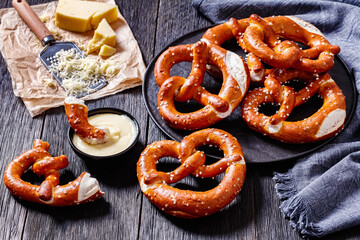 pretzels in the form of knot with cheese sauce