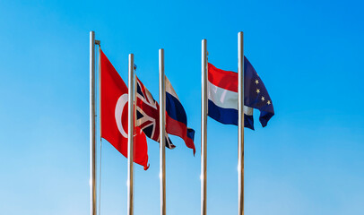 Flags of the European Union - EU, Netherlands, Turkey, Great Britain and Russia against the blue sky. empty flag.