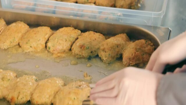 Top view cooking cutlets close up. The chef puts the cutlets in plastic containers for homeless people. Helping low-income people with food.